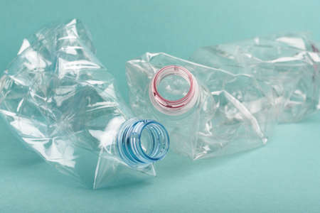 Used crushed plastic bottles on blue background. Recycling concept.