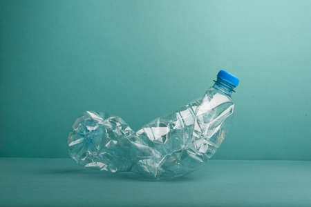 Used crushed plastic bottle on the blue background. Recycling concept.の写真素材