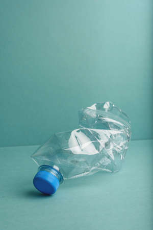 Used crushed plastic bottle on the blue background. Recycling concept.