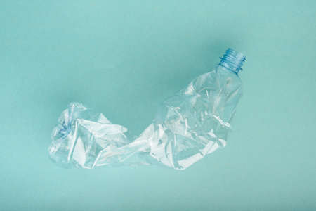 Used crushed plastic bottle on the blue background. Recycling concept.の写真素材