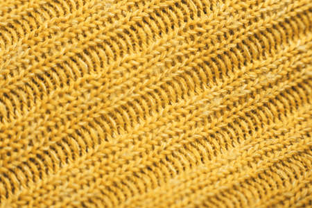 Close up of yellow knitted textured background. Trendy color.