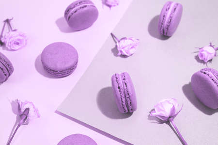 French dessert macarons pattern with rose flowers. Chocolate almond cookies. Flat lay. Trendy color of the year.の写真素材