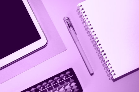 Close up flat lay with laptop, abacus, noteook and pen on purple background. Distance learning online education concept. Back to school concept.の写真素材