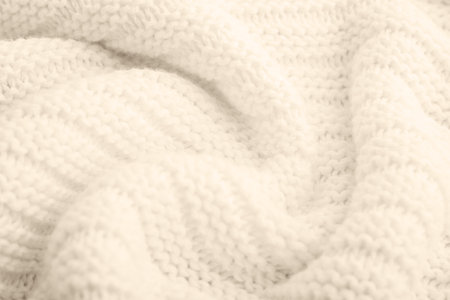 Close up of beige knitted textured background. Trendy color.