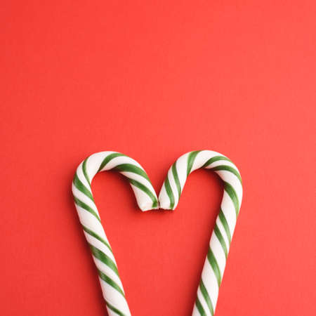 Christmas striped green and white heart shaped hard candies on red backgraund.の写真素材