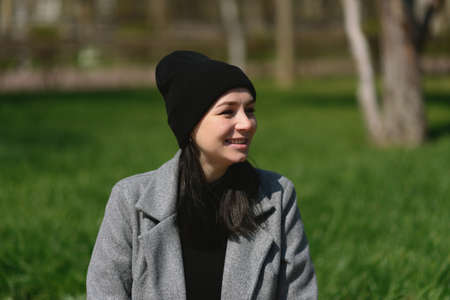 Beautiful girl sitting in the park and enjoying sunlight.の写真素材