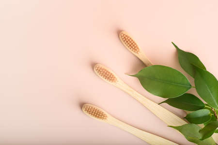 Three eco friendly natural bamboo toothbrushes on pink background.の写真素材