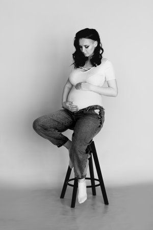 A pregnant woman wearing jeans and white T-shirtの写真素材