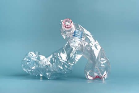 Two used crushed plastic bottles on blue background.の写真素材
