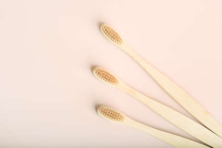 Three eco friendly natural bamboo toothbrushes on pink background.の写真素材