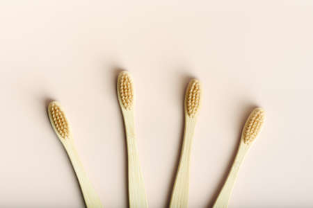 Four eco friendly natural bamboo toothbrushes on pink background.の写真素材