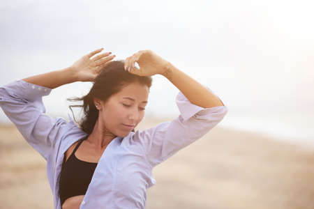 A portrait of beautiful woman stretching her arms up.の写真素材