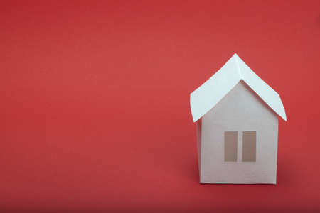 White paper house on red background の写真素材