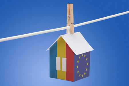 concept - Romania, Romanian and EU flag painted on a paper house hanging on a ropeの写真素材