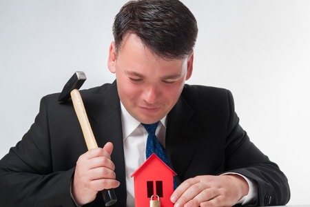 Businessman with hammer on a white backgroundの写真素材
