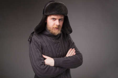 lumberjack in Russian hat, gray background.  looking at cameraの写真素材