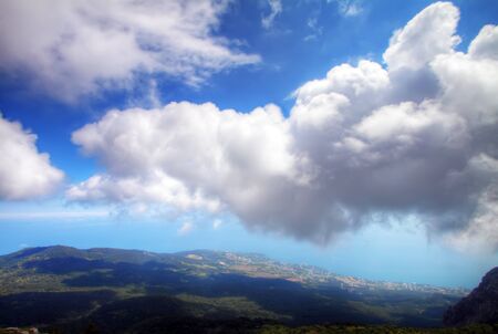 White dense clouds over sea coast reject the big shade. A kind from mountain.の写真素材