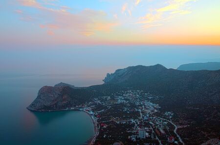 Coast with a small city, the top view on a sunset. A landscapeの写真素材