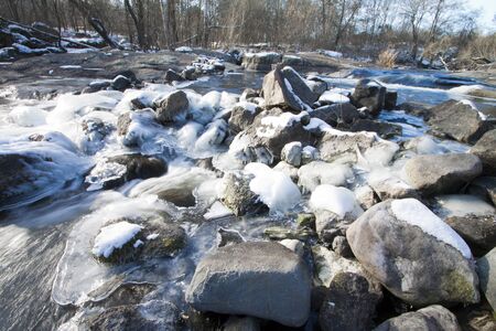 The winter river with ice and stones ahead. A landscape