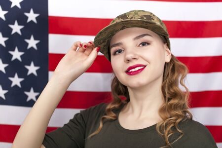 Smiling attractive woman soldier stand in front of American flag.の写真素材