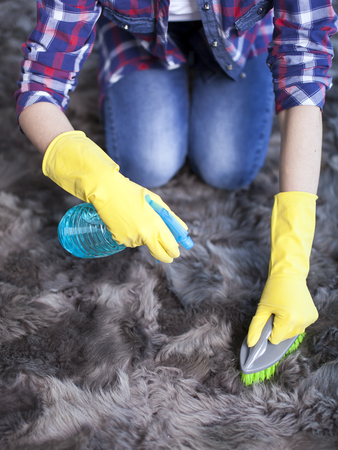 woman sit on carpet ready to cleaning home and smile. Cropped imageの写真素材