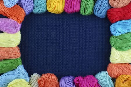 Framework from multi-coloured threads on a dark blue backgroundの写真素材