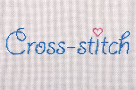 The inscription embroidery a cross with a heart-shaped, made of white canvas