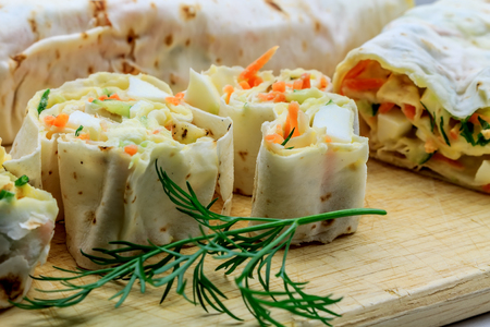 roll of pitta bread, carrot, cucumber, eggs lie on carving board