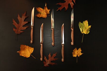 Top view of five knives with a wooden handle on black backgroundの写真素材