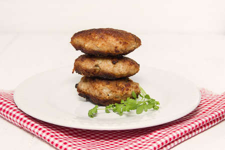 three juicy meat cutlet are on the dishの写真素材