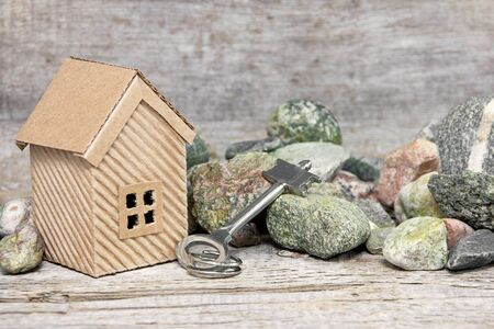house, key and stones on wooden backgroundの写真素材
