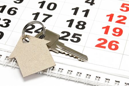 Key and house from a paper on a calendar backgroundの写真素材