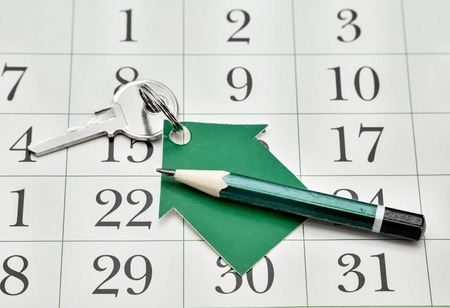 Key, a house made of paper and a pencil against the backdrop of a calendar. Business Detailsの写真素材
