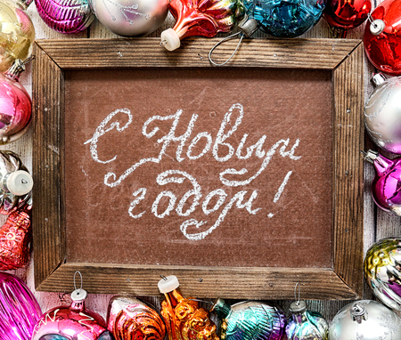 Happy New Year. Festive inscription on the school blackboard and old Christmas toysの写真素材