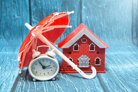 House, umbrella and clock. Safe businessの写真素材