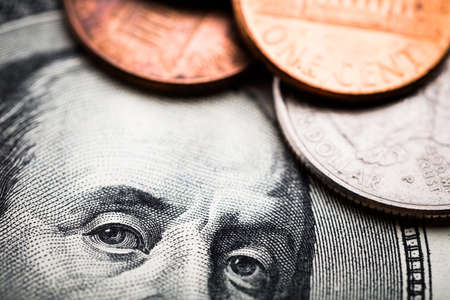 Portrait of Benjamin Franklin from one hundred dollars banknote and cents coins shots in macro lens close-upの写真素材