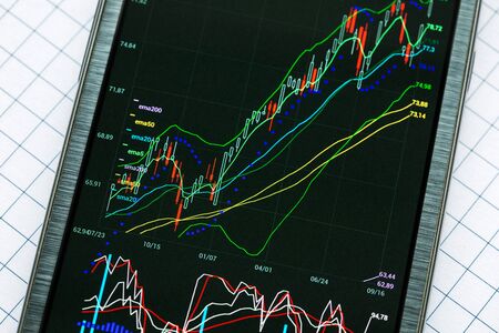Data analyzing in stock exchange market: the charts and quotes on smartphone display.