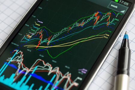 Data analyzing in stock exchange market: the charts and quotes on smartphone display.の写真素材