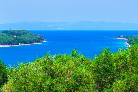 Wonderful romantic summer afternoon landscape panorama coastline Adriatic sea. Boats and yachts in harbor at magical clear transparent azure water. Olive trees grove. Cres island. Croatia. Europe.の写真素材