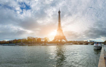 Panoramic view of the Eiffel Tower and Jena bridge from the river Seine embankment, Paris, France. Autumn. Beautiful sitycape in backlit morning sunbeam.の写真素材