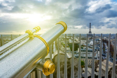 Touristic telescope or spyglass in rain drops directed towards the Eiffel Tower. Paris. France.