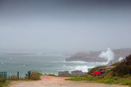 A huge ocean waves breaking on the coastal cliffs in at the cloudy stormy day. Breathtaking romantic seascape of ocean coastline.の写真素材