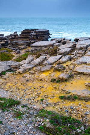 A huge ocean waves breaking on the coastal cliffs in at the cloudy stormy day. Breathtaking romantic...