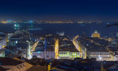 Night long exposure aerial cityscape. View of historic central quarters, Commerce Square, Triumphal Rua Augusta Arch and Tagus river in evening illumination, Lisbon, Portugal.の写真素材