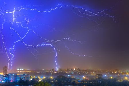 Lightning over the city at the summer storm. Dramatic, breathtaking atmospheric natural phenomenon.