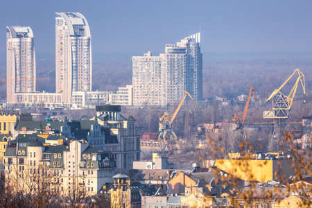 Early spring at sunny evening in warm weather. Industrial zone and residential areas Podin and northern suburbs Obolon in Kyiv on the right bank of the Dnipro River. Ukraine Mar. 6, 2019のeditorial素材