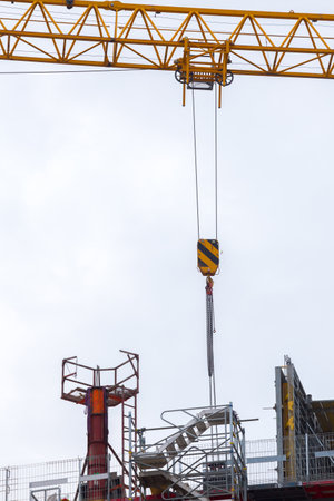 Tower mast crane. Hoisting block with hook on steel chain on the steel rope. Loading\unloading of...