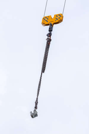 Crane hoisting block with hook on steel chain on the steel rope. Loading\unloading of building...