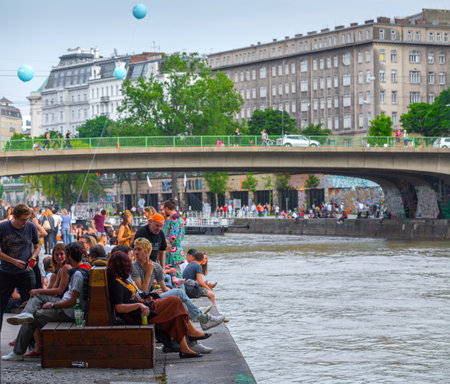 VIENNA, AUSTRIA - MAY 25: Many people are relaxing with alcohol drinks on a day off in a beautiful summer weather on the banks of the Danube Canal(Donaukanal) in Vienna, Austria, on May 25, 2019.のeditorial素材