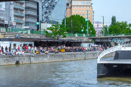 VIENNA, AUSTRIA - MAY 25: Many people are relaxing with alcohol drinks on a day off in a beautiful summer weather on the banks of the Danube Canal(Donaukanal) in Vienna, Austria, on May 25, 2019.のeditorial素材